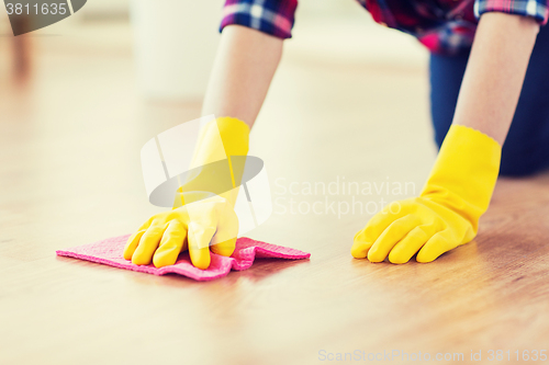 Image of close up of woman with rag cleaning floor at home