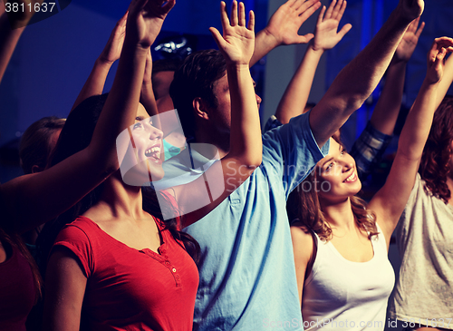 Image of smiling friends at concert in club