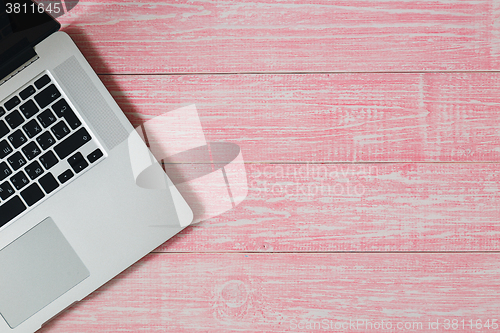 Image of Laptop on a pink wooden desk