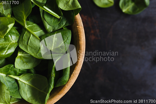 Image of Fresh spinach leaves in a wooden bowl