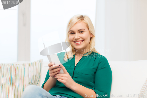 Image of happy woman with smartphone at home