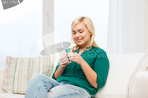 Image of happy woman with smartphone at home