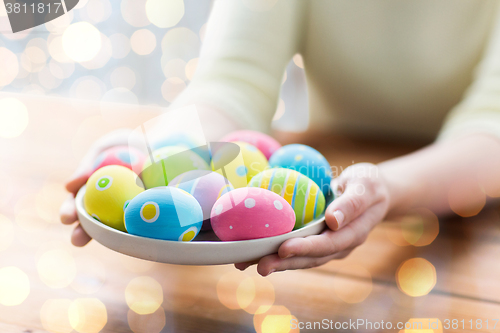 Image of close up of woman hands with colored easter eggs