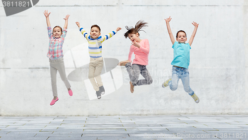 Image of happy little girl jumping in air on street