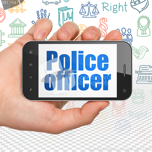 Image of Law concept: Hand Holding Smartphone with Police Officer on display