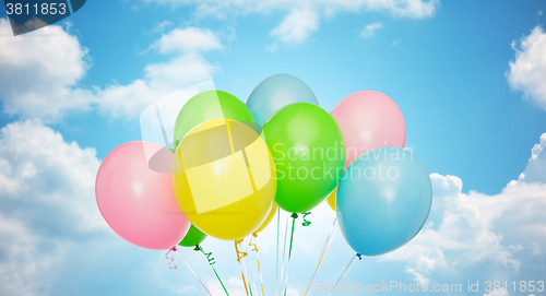 Image of bunch of inflated helium balloons over blue sky
