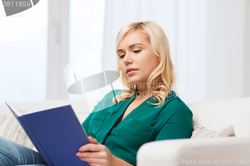 Image of woman reading book at home