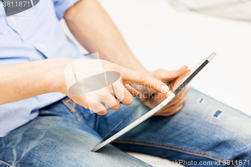 Image of close up of man working with tablet pc at home