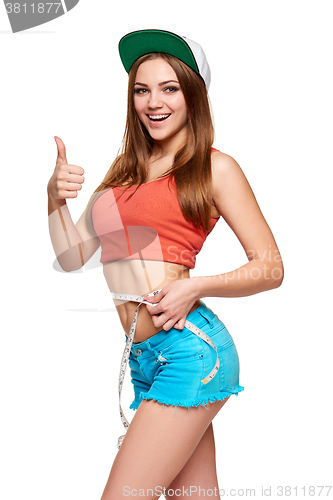 Image of Excited teen girl measuring her waist 
