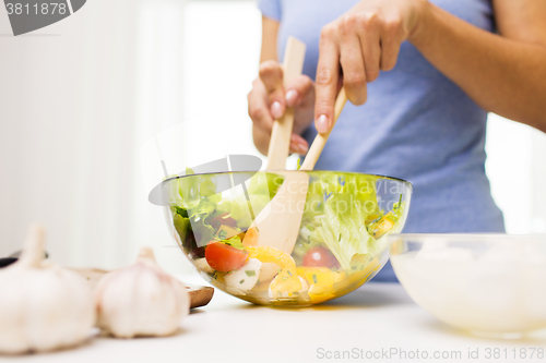 Image of close up of woman cooking vegetable salad at home