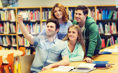 Image of students with smartphone taking selfie in library