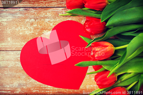 Image of close up of red tulips and paper heart shape card