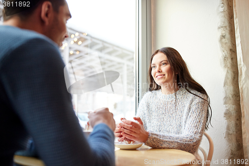Image of happy couple drinking tea and coffee at cafe