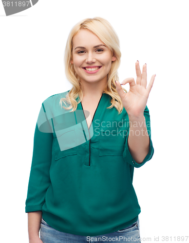 Image of smiling young woman in shirt showing ok hand sign