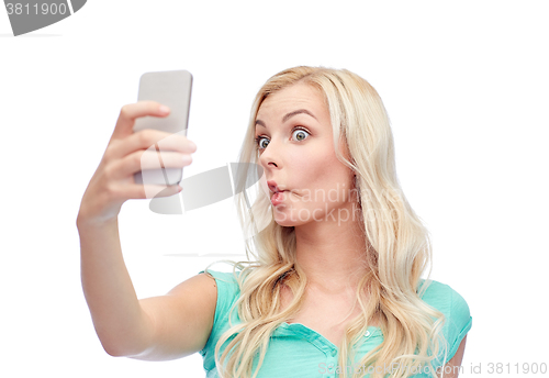 Image of funny young woman taking selfie with smartphone
