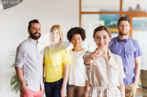 Image of woman pointing to you over creative office team