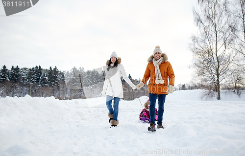 Image of happy family with sled walking in winter outdoors