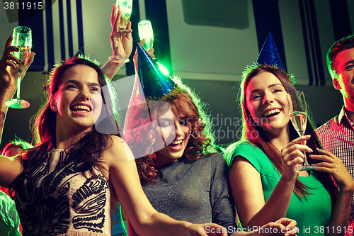 Image of smiling friends with glasses of champagne in club