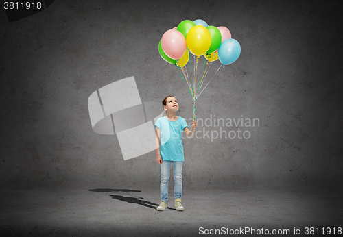 Image of girl looking up with bunch of helium balloons