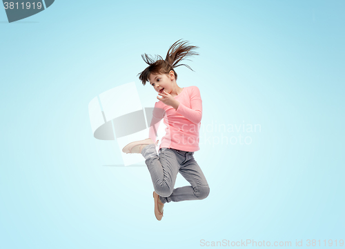 Image of happy little girl jumping in air over blue