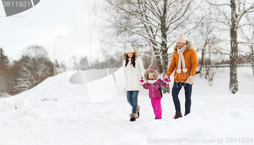 Image of happy family in winter clothes walking outdoors