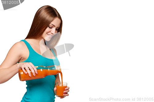 Image of Woman pouring carrot juice in a glass