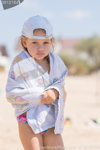 Image of Frozen four-year girl standing on the sandy beach sea