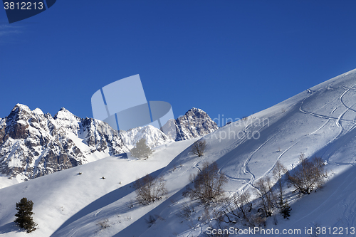 Image of Off-piste slope with track from ski and snowboard on sunny morni