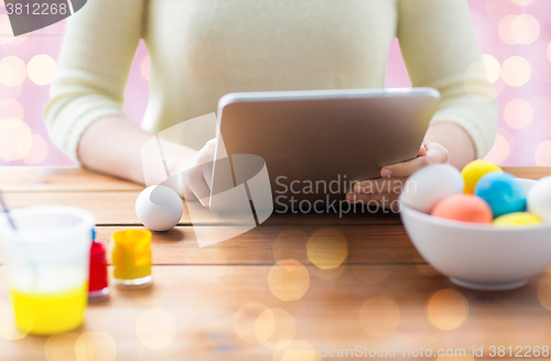 Image of close up of woman with tablet pc and easter eggs