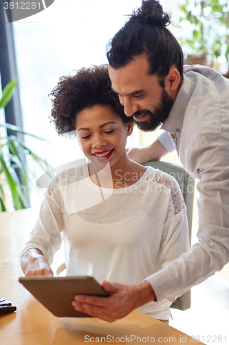 Image of happy creative team with tablet pc in office