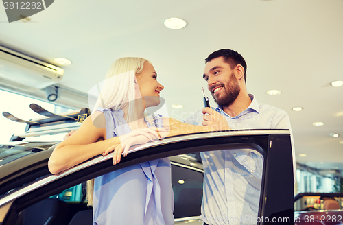 Image of happy couple buying car in auto show or salon