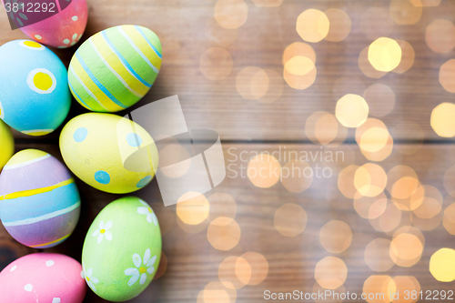 Image of close up of colored easter eggs on wooden surface