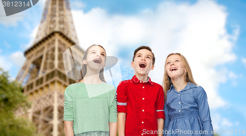 Image of amazed children looking up over eiffel tower