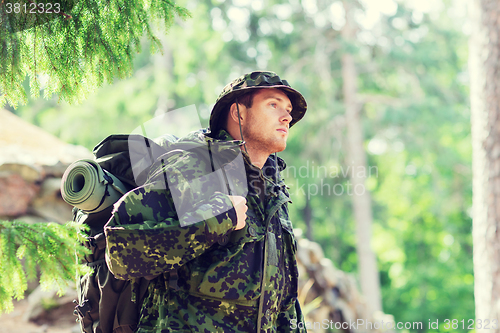 Image of young soldier with backpack in forest