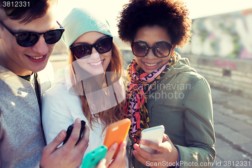 Image of smiling friends with smartphones