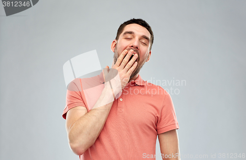 Image of yawning man over gray background