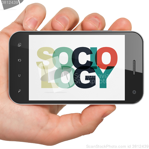 Image of Studying concept: Hand Holding Smartphone with Sociology on  display