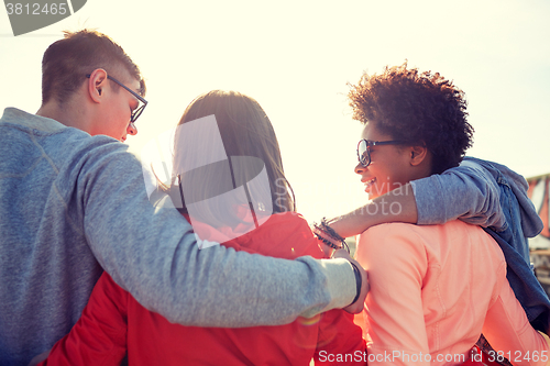 Image of happy teenage friends in shades hugging on street