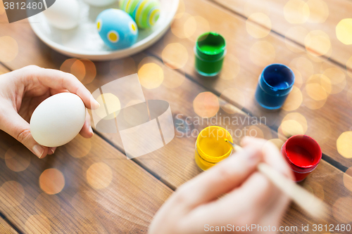 Image of close up of woman hands coloring easter eggs