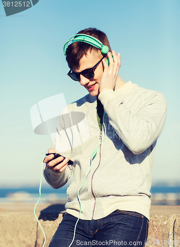 Image of happy young man in headphones with smartphone
