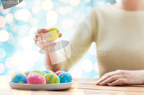 Image of close up of woman hands with colored easter eggs