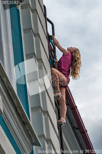 Image of Pretty woman evacuates on fire escape stair