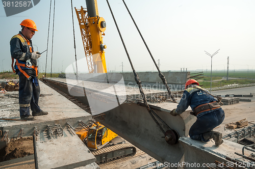 Image of Two workers mouning bridge span