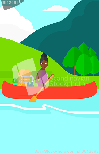 Image of Woman canoeing on the river.