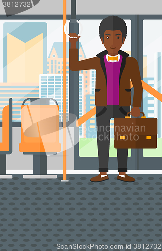 Image of Man standing inside public transport.