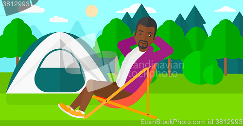 Image of Man sitting in folding chair.
