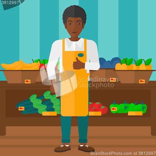 Image of Supermarket worker with box full of apples.