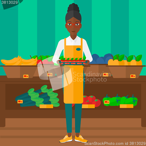 Image of Supermarket worker with box full of apples.