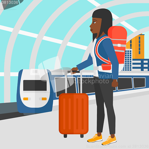 Image of Woman with suitcase on wheels and briefcase.