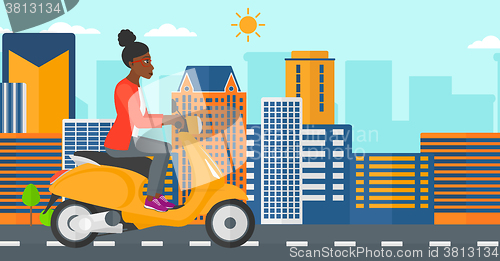 Image of Woman riding scooter.